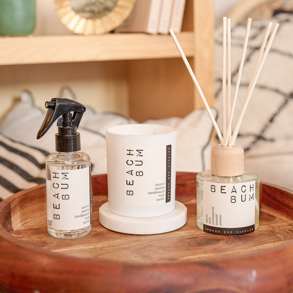 Three 'Beach Bum' products on a wooden tray with a blurred background