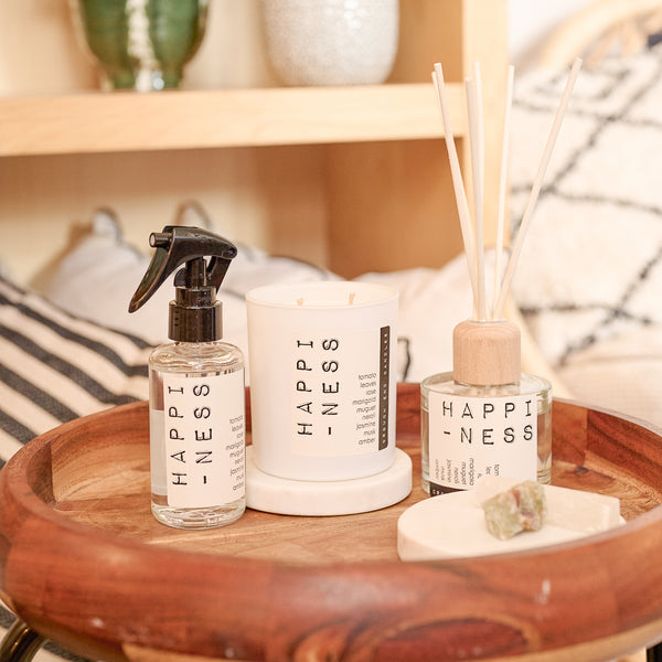 Decorative items on a wooden tray including bottles labeled 'HAPPINESS'.