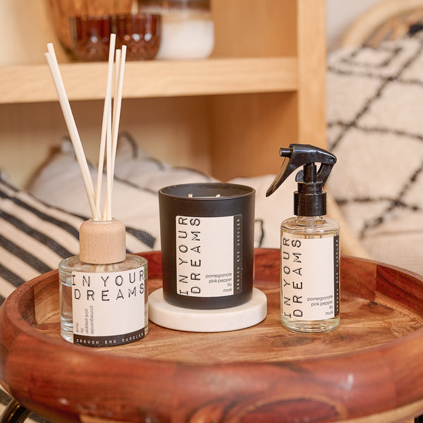 Three 'In Your Dreams' products on a wooden tray with a blurred background