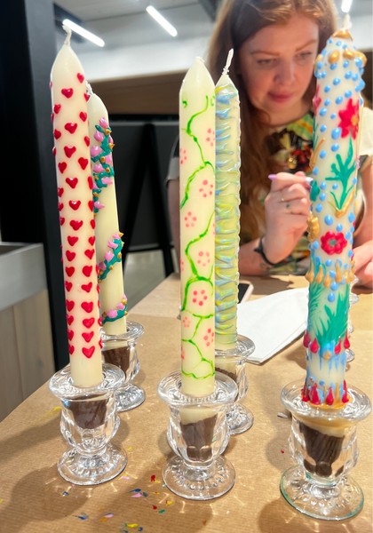 Decorative candles on small glass stands with a person in the background.