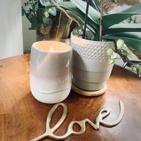 GREY OMBRE EFFECT GLAZED CANDLE AND  PLANT POT ON WOODEN TABLE WITH THE WORD 'LOVE' 